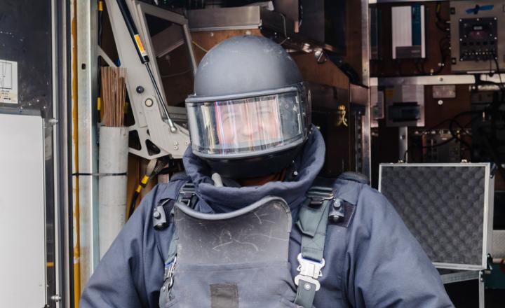 A man wearing a bomb-proof helmet with shield